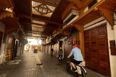 Guided e-bike tour group cycling through the historic Bab el-Had gate in Rabat.