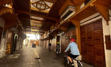 Guided e-bike tour group cycling through the historic Bab el-Had gate in Rabat.