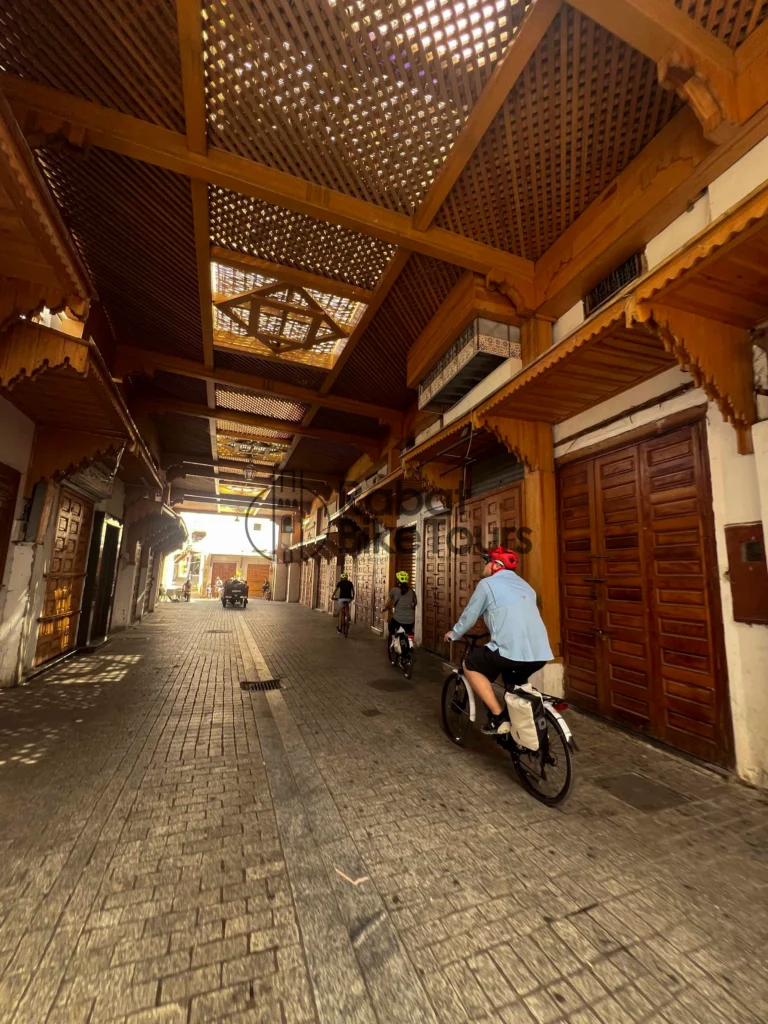 Guided e-bike tour group cycling through the historic Bab el-Had gate in Rabat.