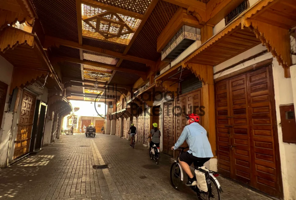 Guided e-bike tour group cycling through the historic Bab el-Had gate in Rabat.