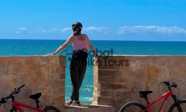 Guided e-bike tour group cycling past the ocean in Rabat.