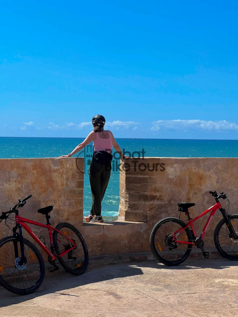 Guided e-bike tour group cycling past the ocean in Rabat.